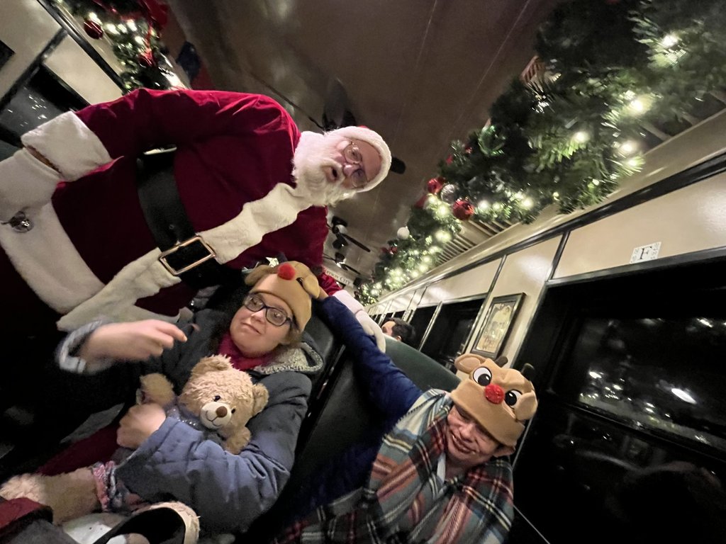 Two people posing with santa