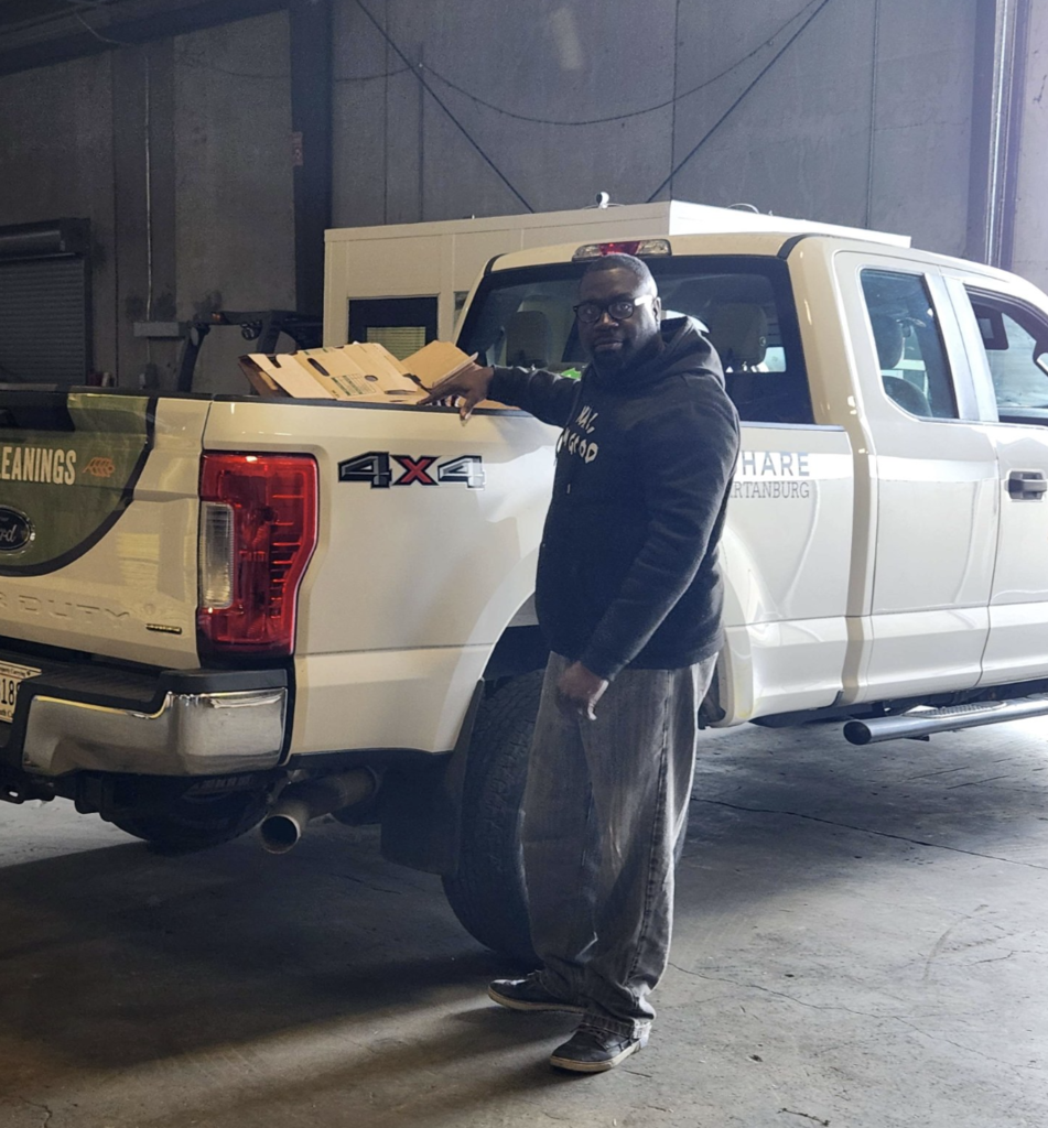 Man beside a truck with a box