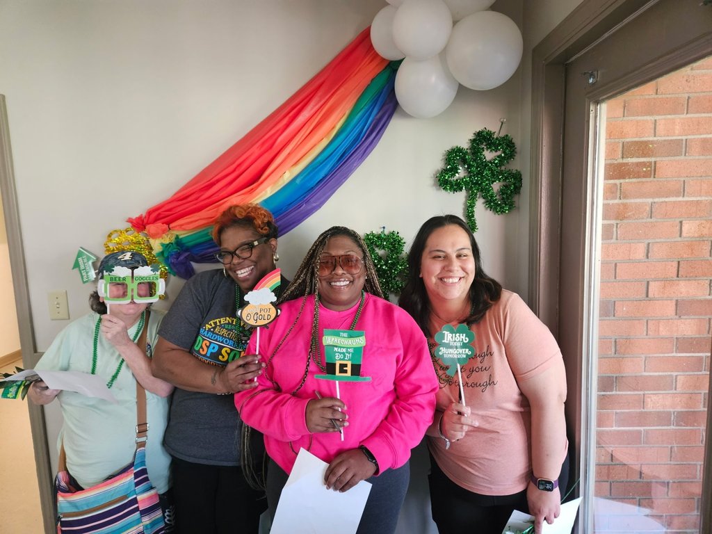 4 women in front of a rainbow