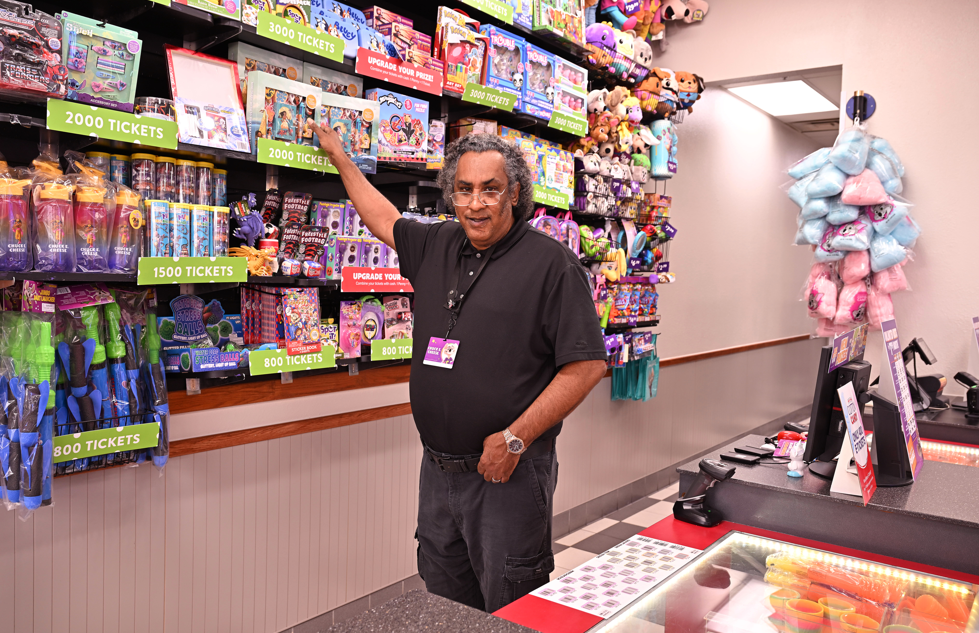 Man in front of gift wall at ChuckECheese