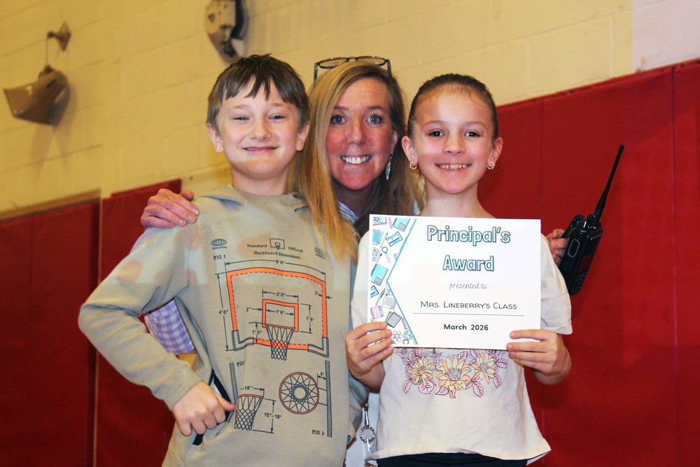 woman smiling with boy and girl holding Principal's Award certificate
