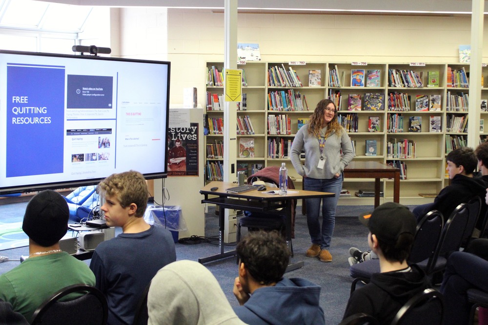 woman talking before student audience in  school library