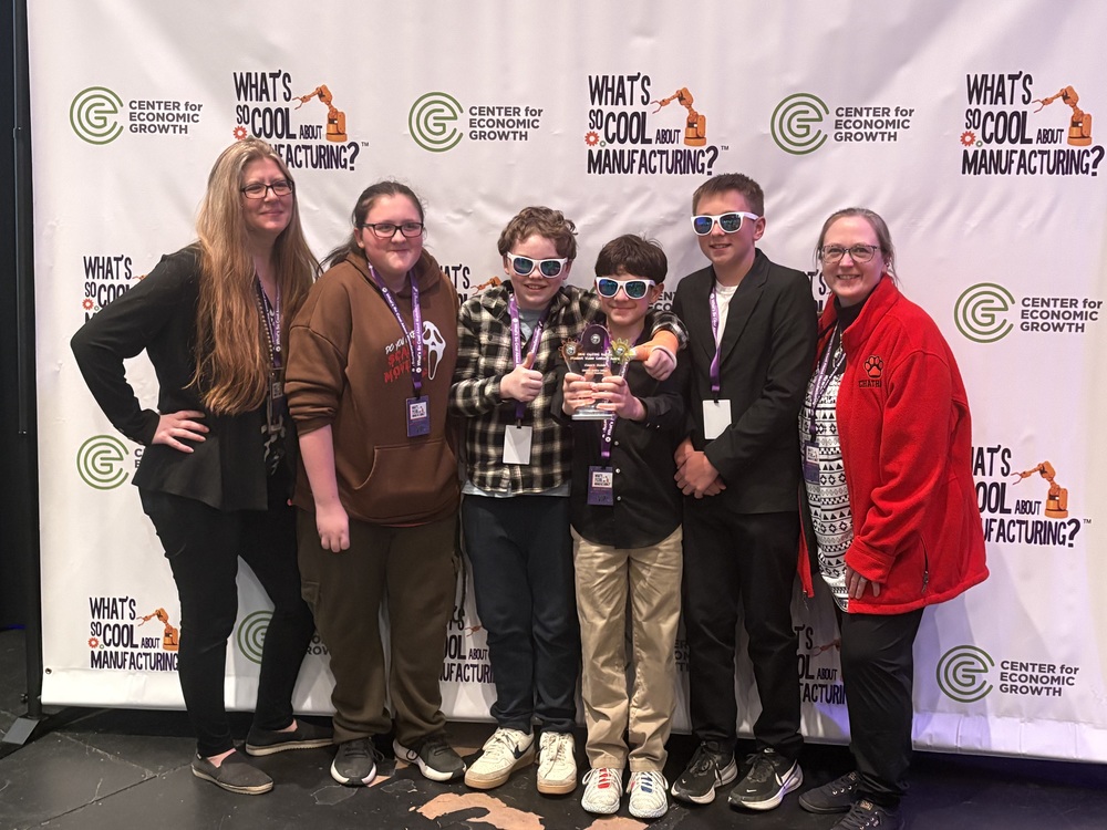 What's So Cool About Manufacturing Club poses for photo with trophy