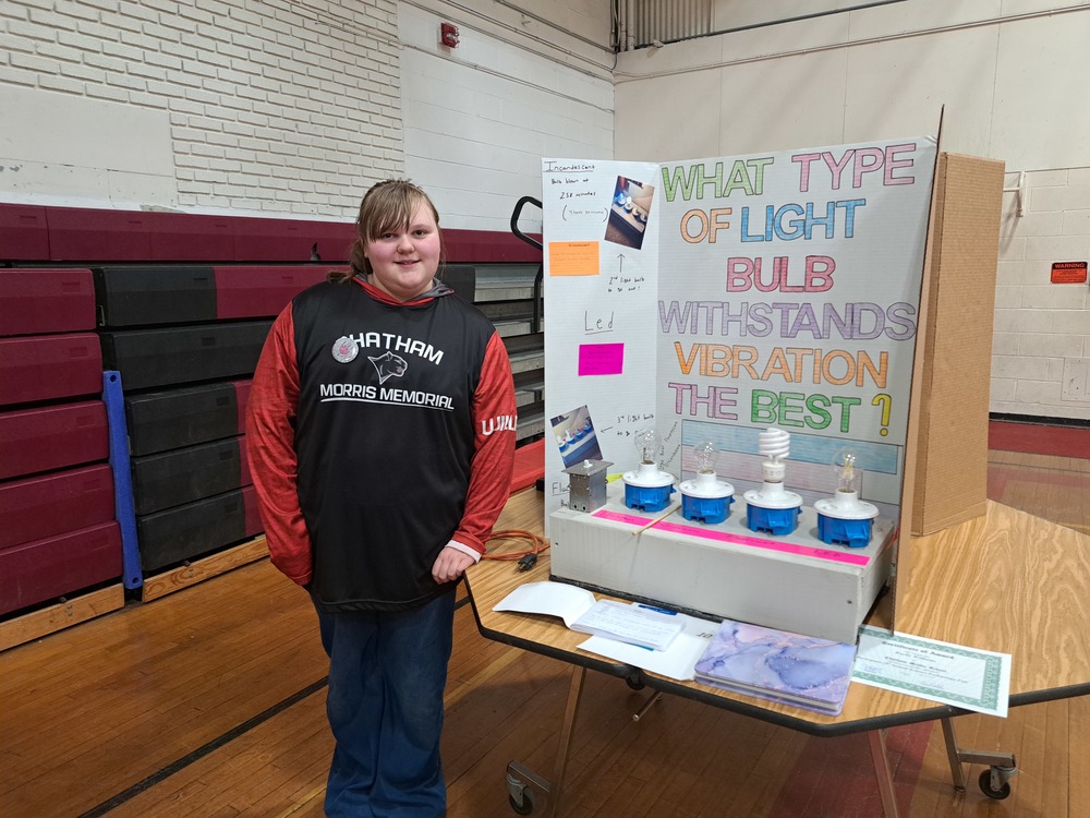 Girl posing with science fair experiment 