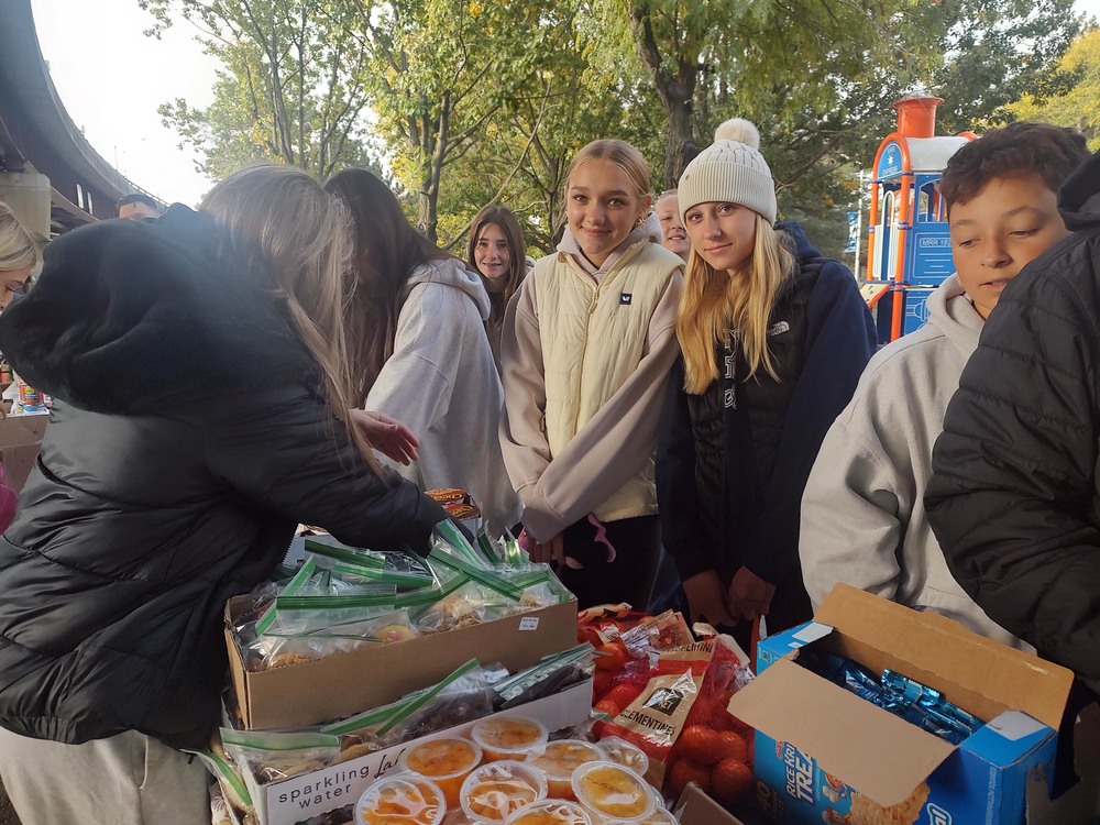 students at table filled with food an other essentials