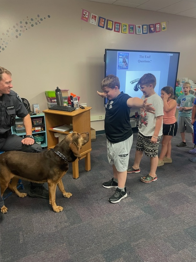 boy greeting police bloodhound