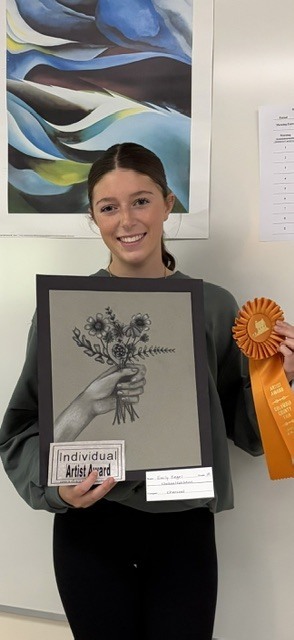 young woman holding charcoal drawing of a hand holding bouquet of flowers
