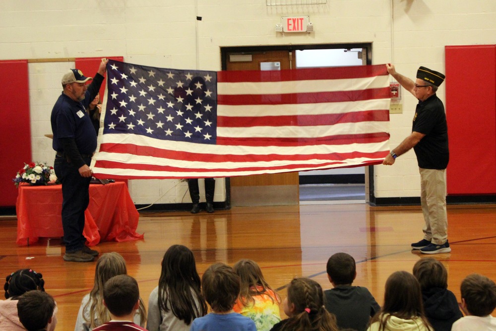 two men folding United States Flag