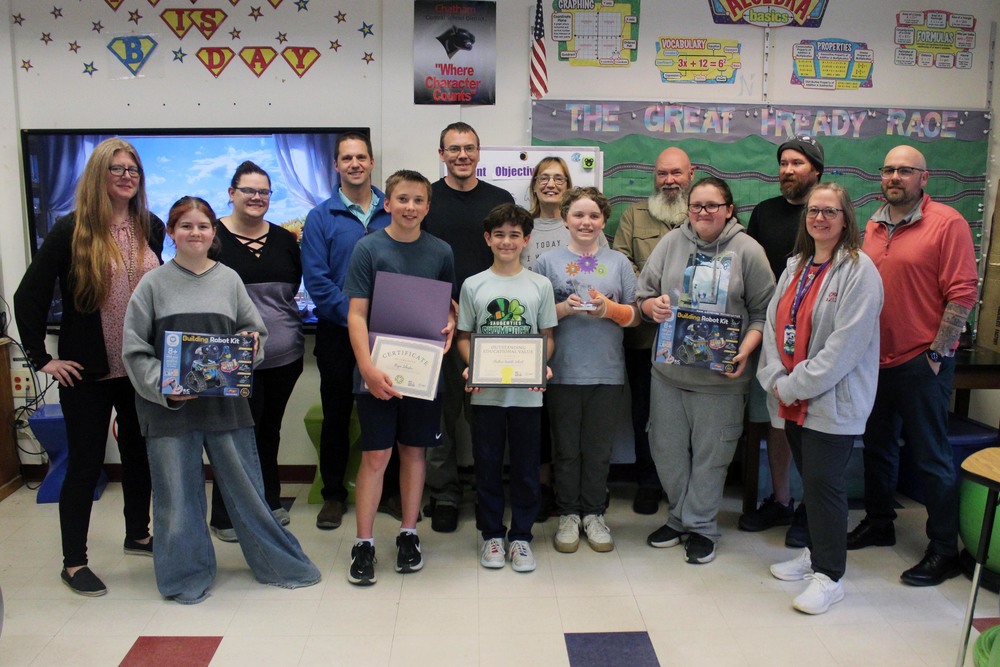 team members holding robotics kits and certificates  pose with Sonoco representatives