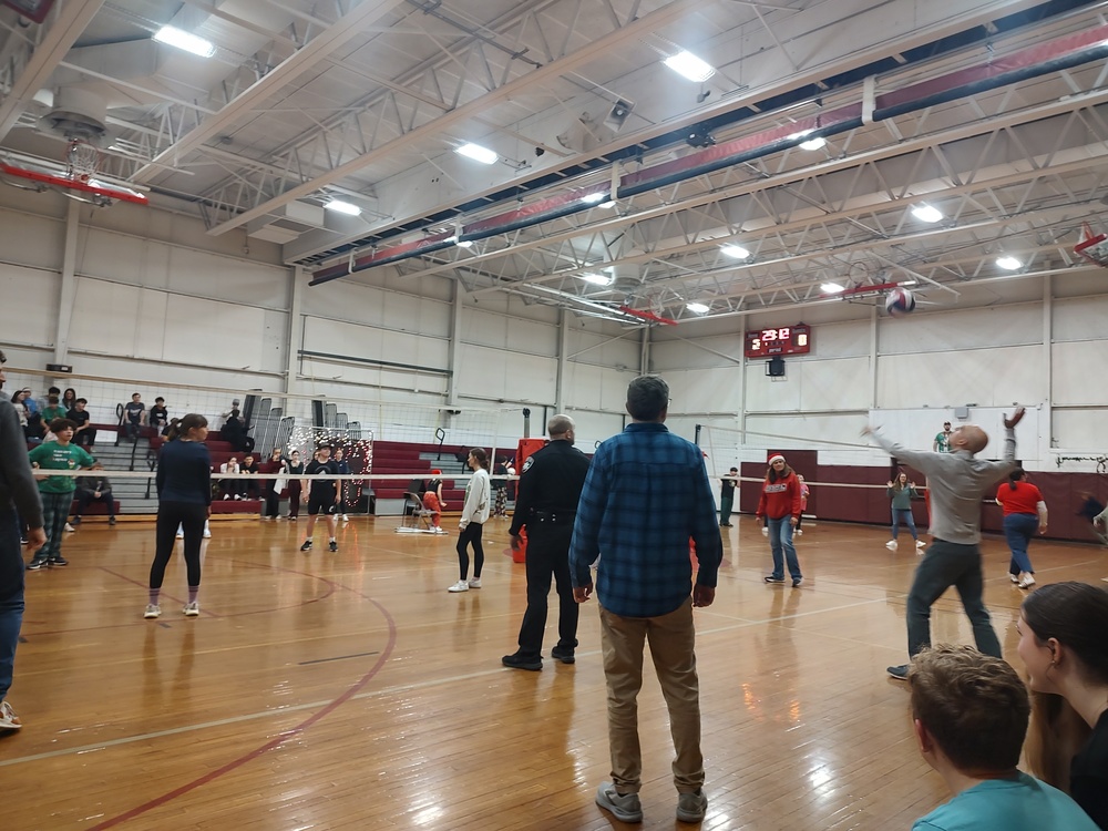 peole play volley ball in school gym