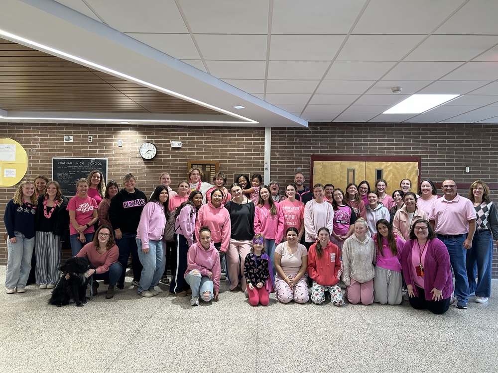 group photo of students and staff wearing pink