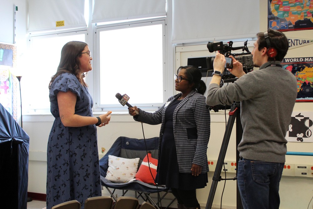 woman being interviewed by reporter and TV camera man.