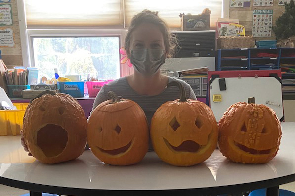 woman with four carved pumpkins