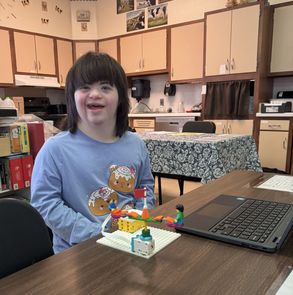 smiling girl with miniature carousel and laptop