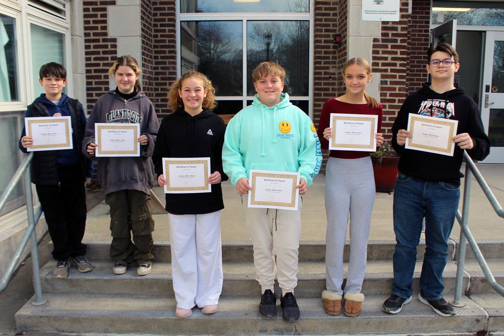 six miidle school students pose for photo with student of the month certificates
