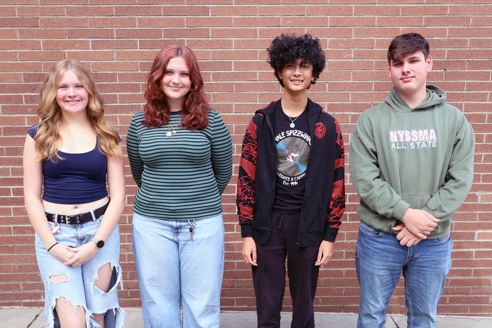 two girls and two boys pose for photo outside school