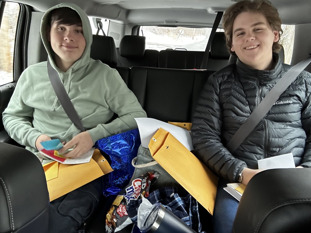 two teenage boys with cards  sitting in passenger van.