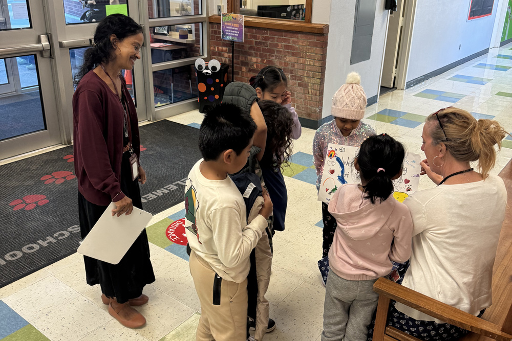 students and woman giving card to woman