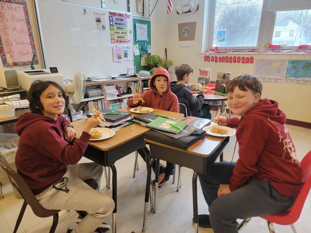 boys eating lo mein with chop sticks
