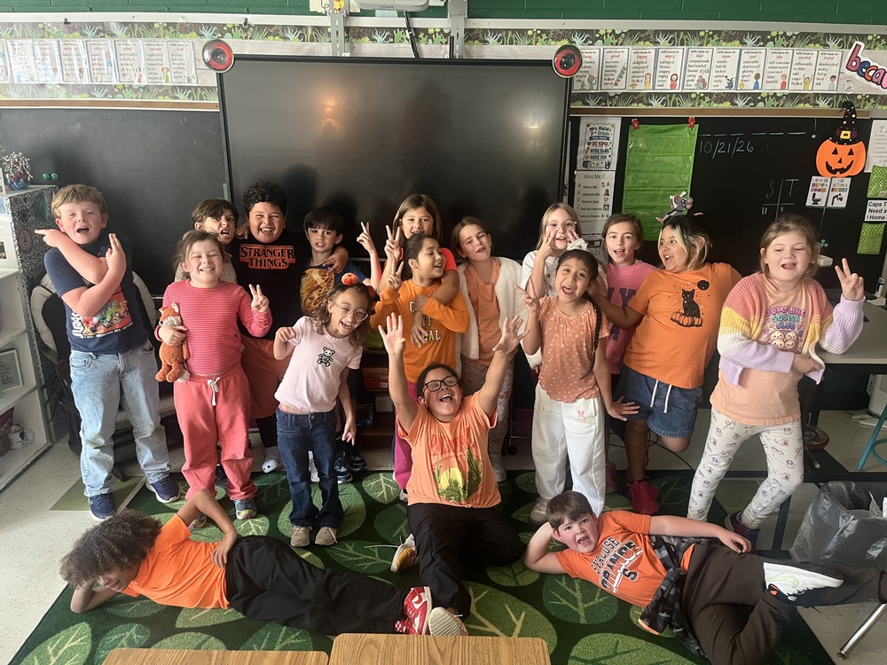 large group of students celebrating wearing orange