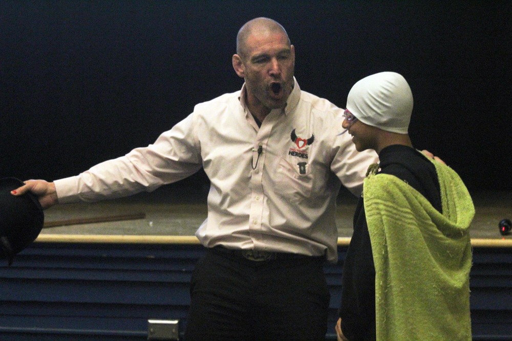 man talking to student in cape