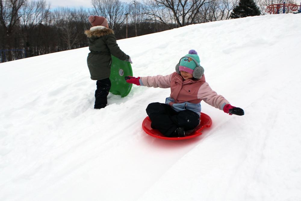 kids sledding on hill