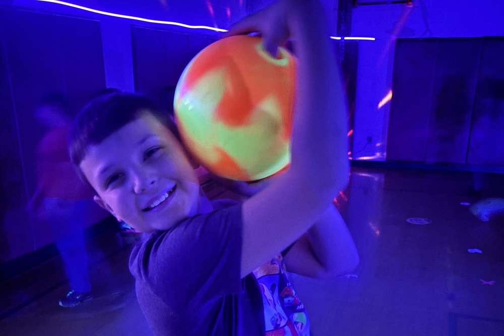 boy holding glowing bowling ball