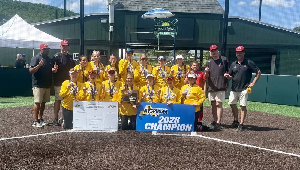 varsity softball team with ny state champion banner
