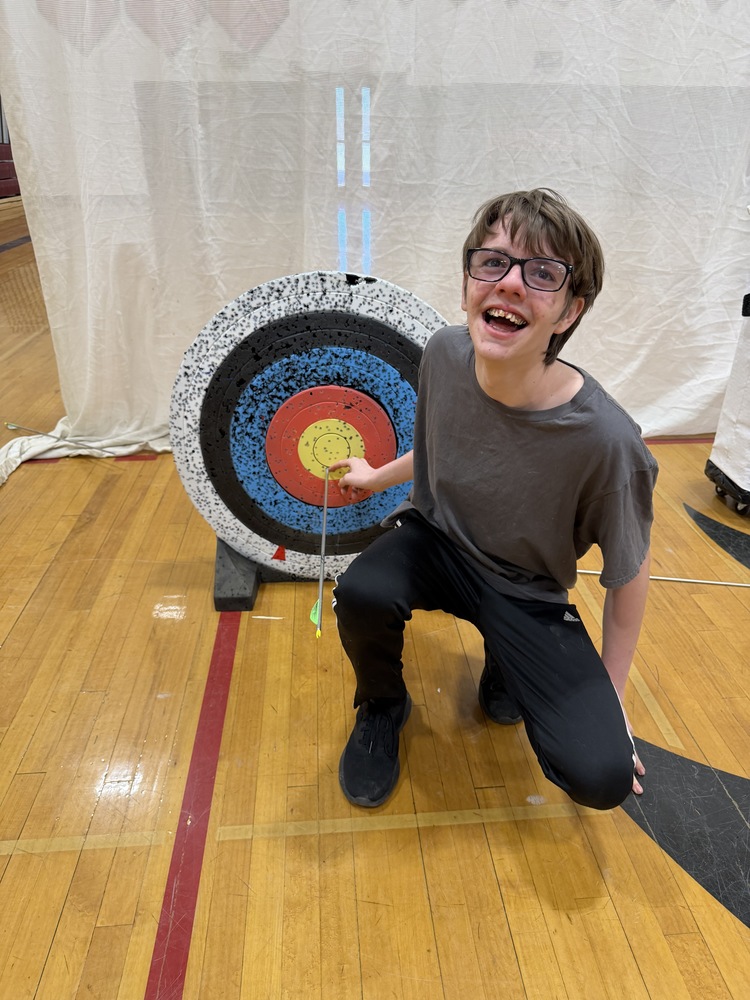 smiling student poses with bullseye
