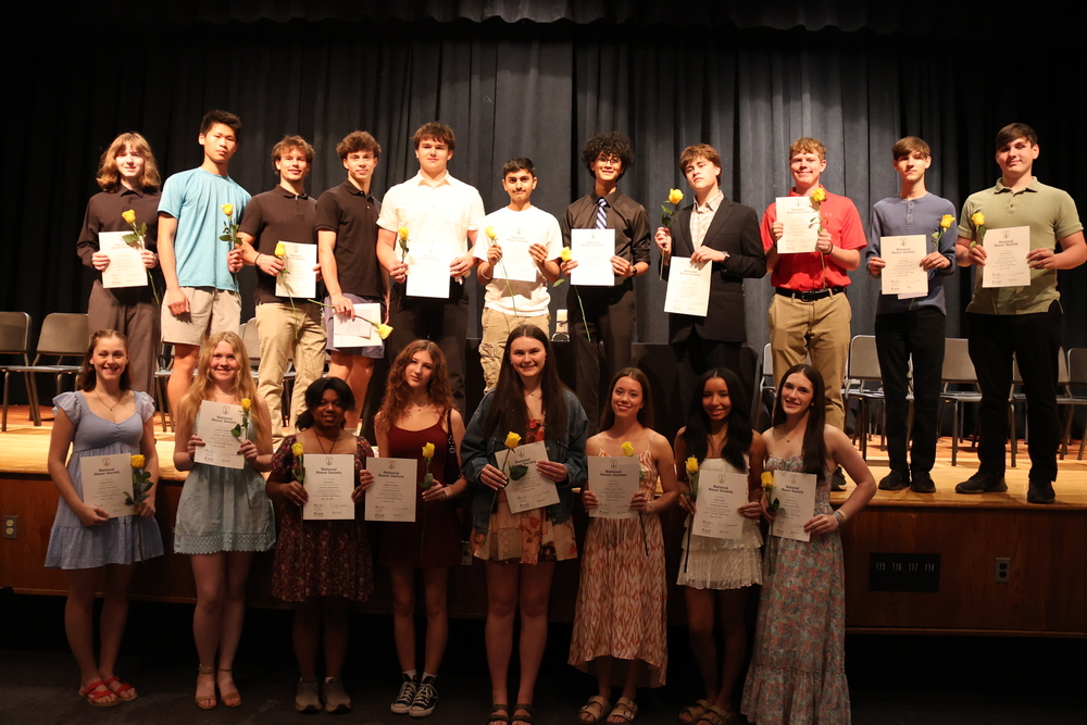 National Honor Society inductees on stage  holding certificates