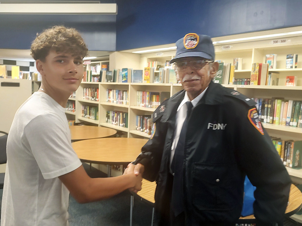 Boy shaking man in FDNY uniform's hand