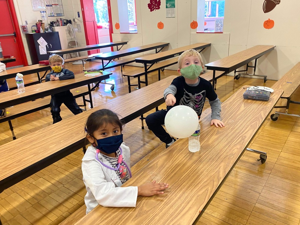 Students watching white balloon inflate