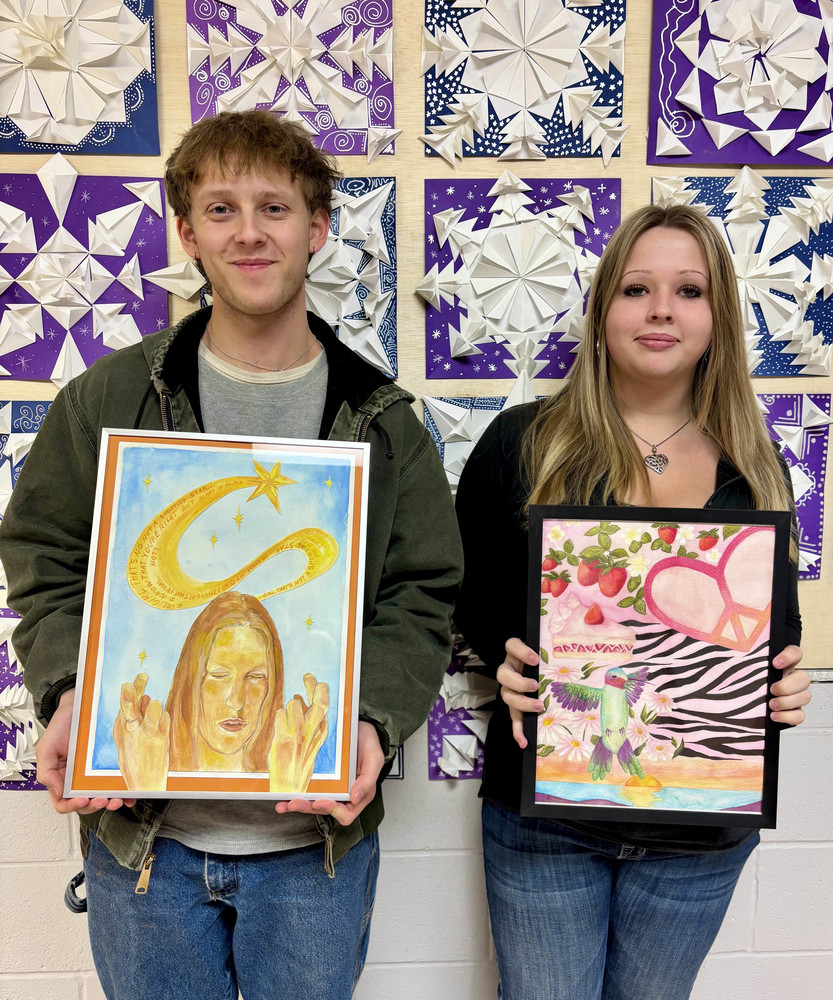 Teenage boay and girl holding artwork