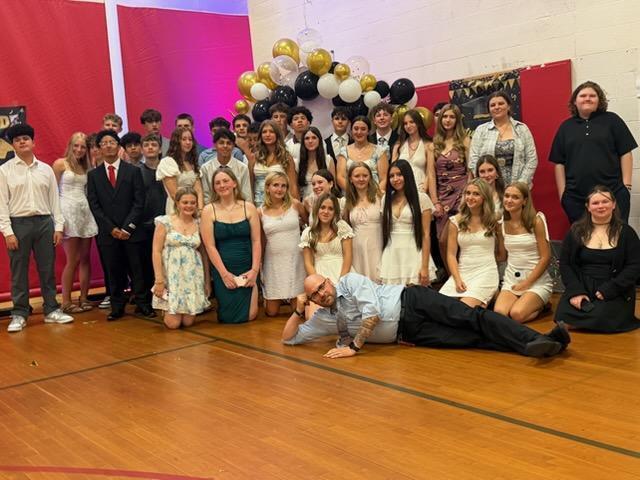 group photo of eighth grades posing with Principal Fortran in gym