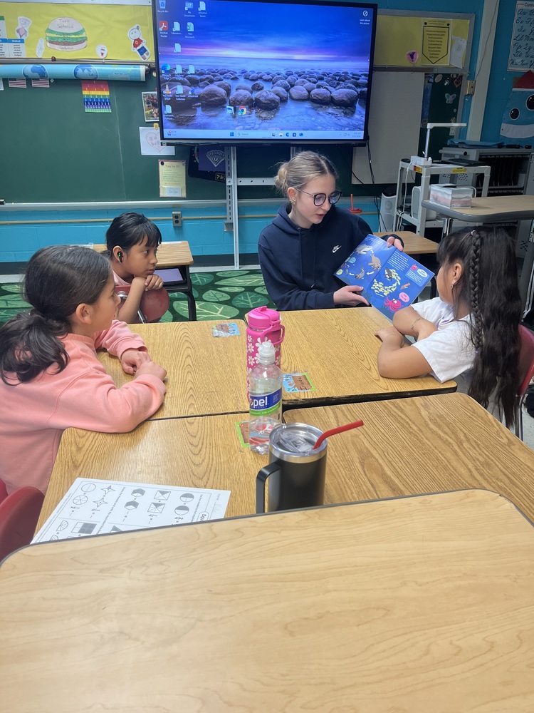 girl reading to younger children