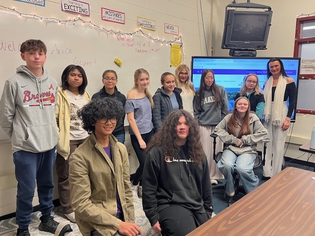 students and woman pose for group photo