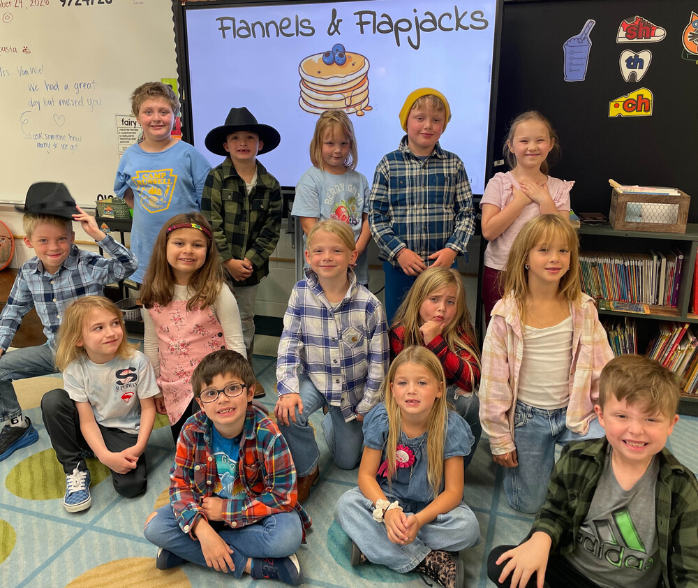 students wearing flannels or blue clothing pose for class photo