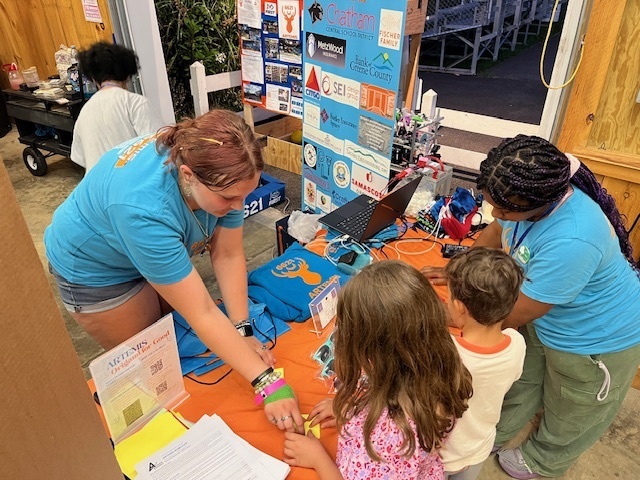 girl showing students robot team items