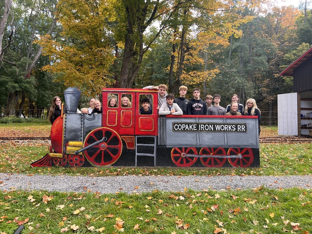 students posing for photo in train cutout