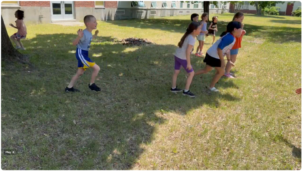students having water balloon fight on school lawn