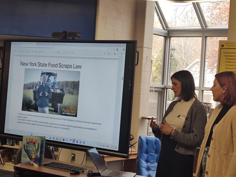 two women giving presentation to class on food scraps lawe