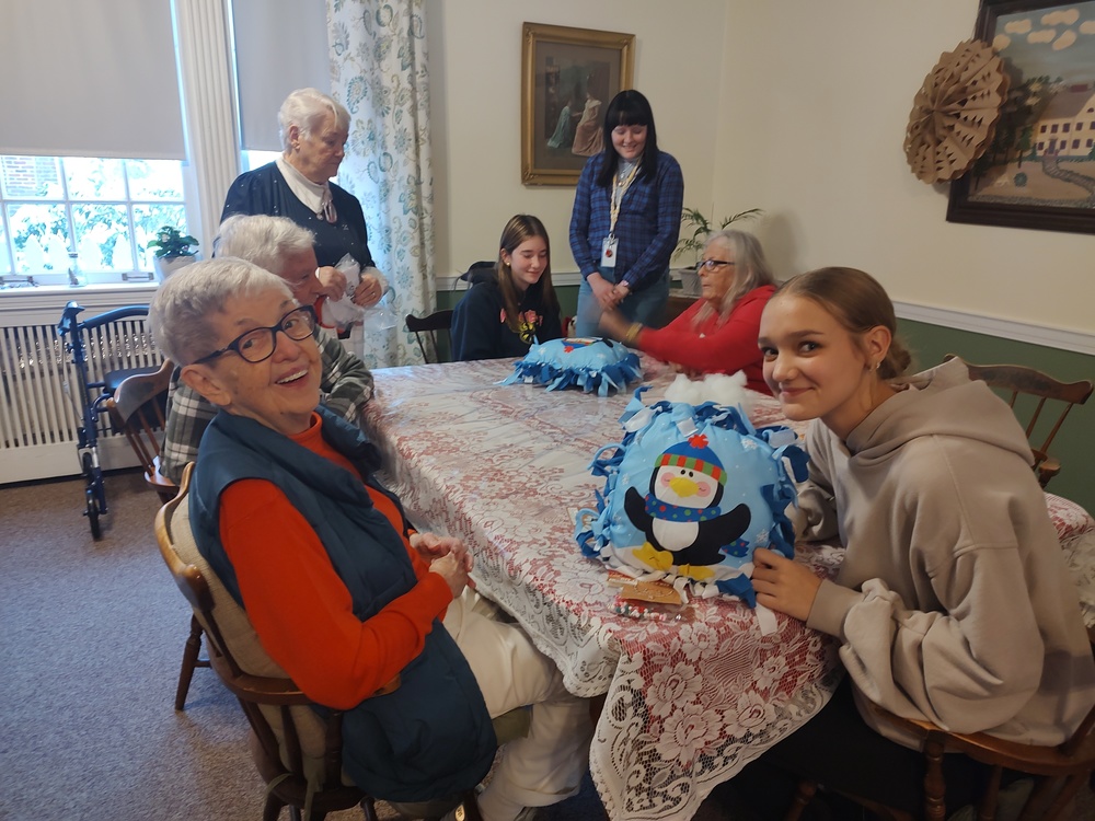 students and seniors making pillows at table 