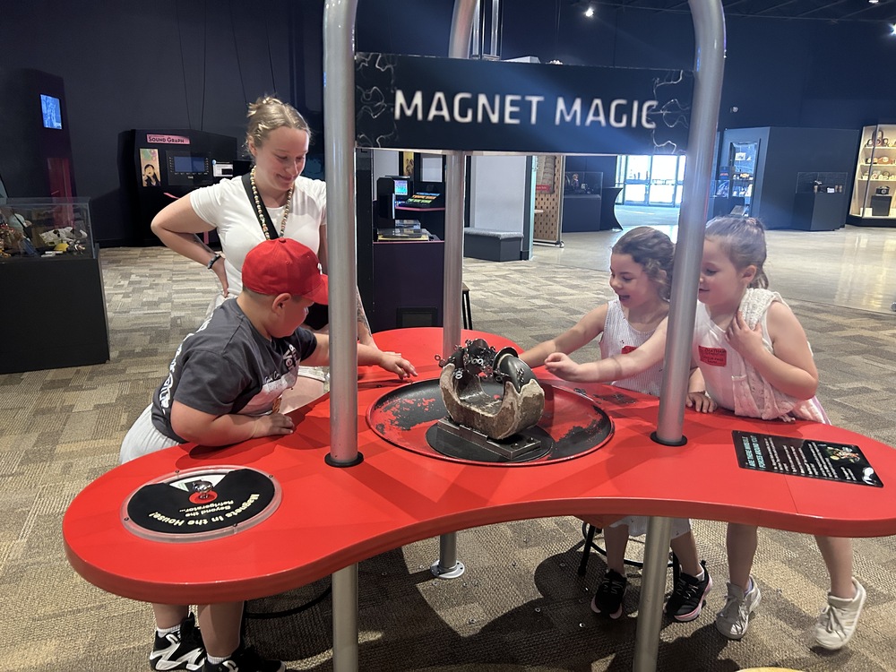 students playing with magnet exhibit