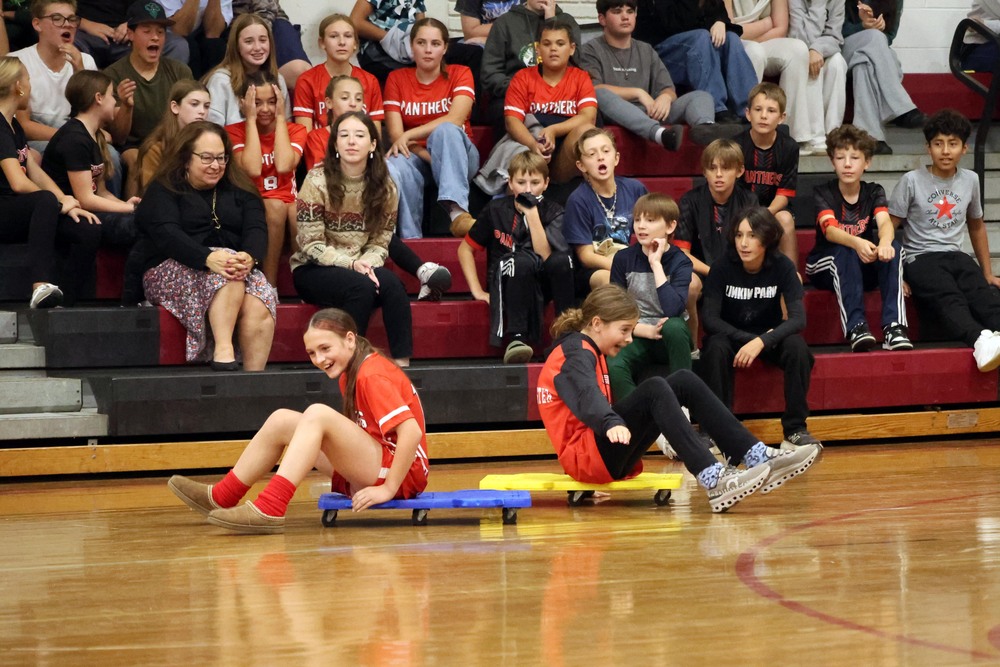 two girls racing on floor dollies