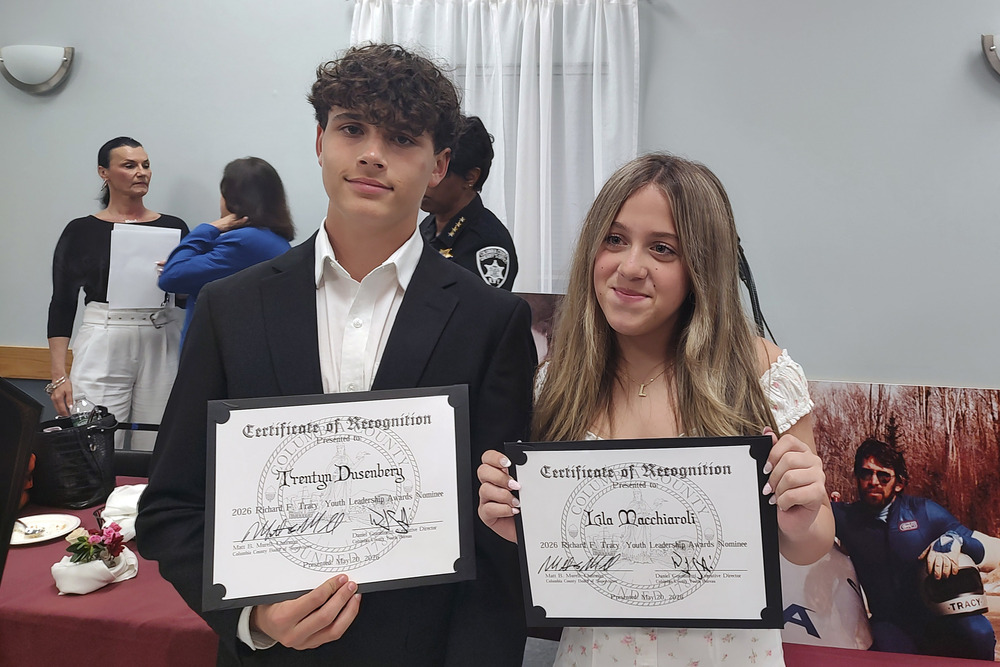 Boy and girl holding certificates of recognition