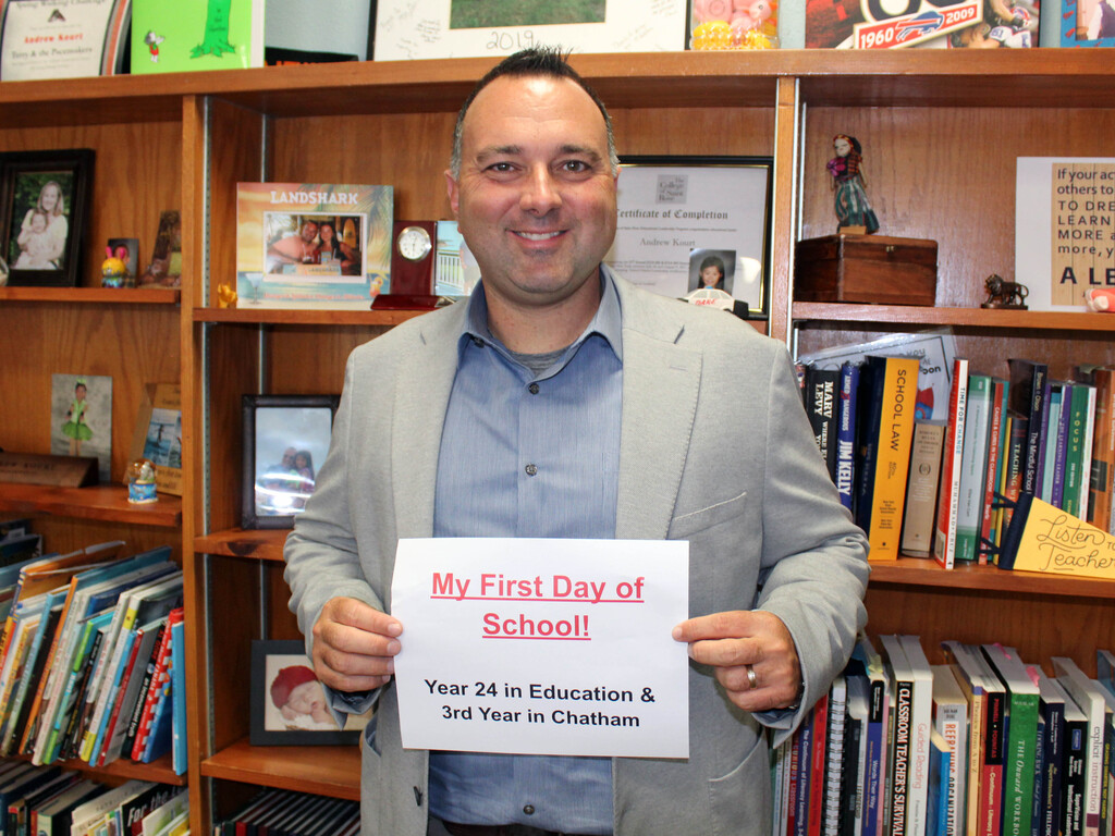 superintendent Andrew Kourt holding first day of school sign