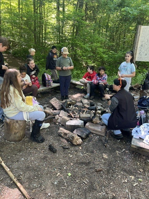 students gathered around campfire