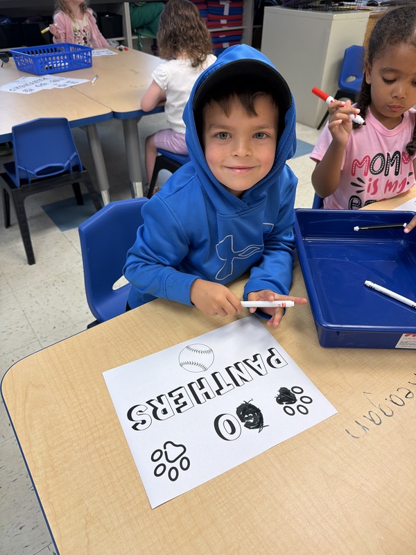 boy making go panthers sign