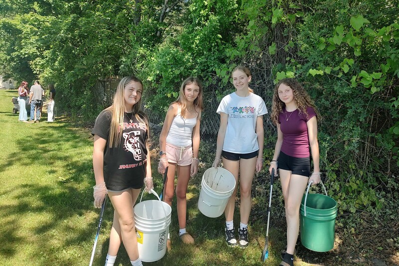 four girls pose with buckets