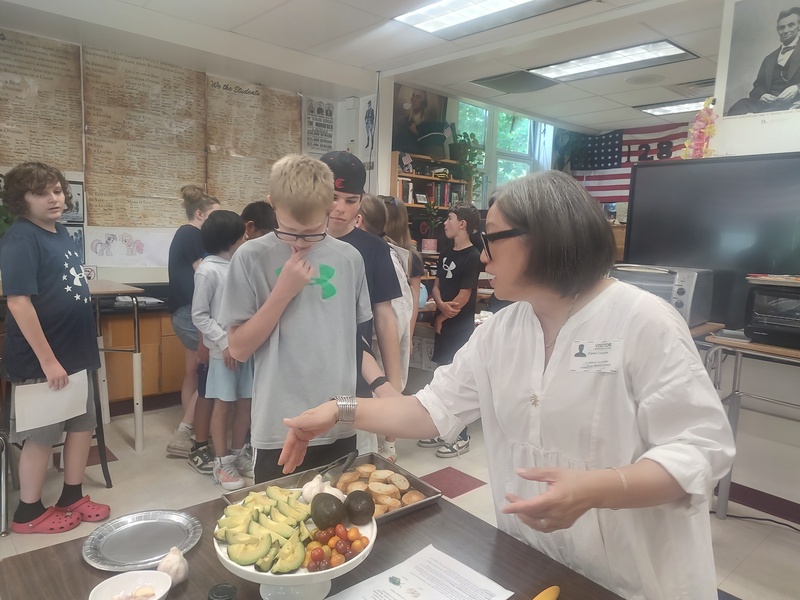 woman showing students how to make snacks
